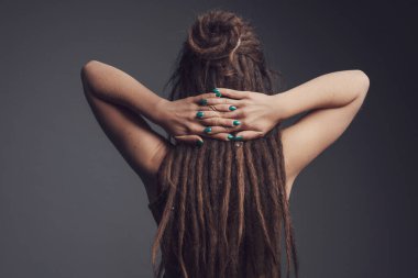 Genç bir kadının yakın plan portresi. Rasta ve uzun saç arkası.