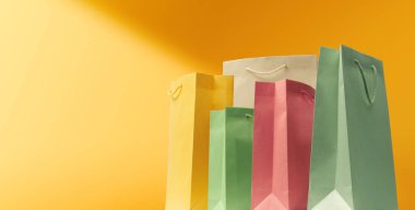 Sarı arka plan, satış ve alışveriş afişlerinde çeşitli alışveriş çantaları koleksiyonu