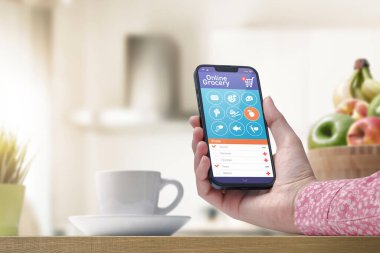 Akıllı telefon uygulaması üzerinden marketten sipariş veren kadın telefonu tutuyor ve listedeki maddeleri seçiyor, POV fotoğrafı.
