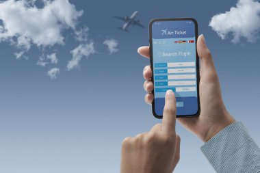 Akıllı telefonu olan ve ucuz uçuşları internetten ayarlayan kullanıcı, arka planda gökyüzü, POV görüntüsü