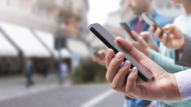 People focused on their smartphones in the city street, technology and addiction concept
