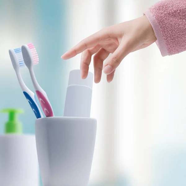バスルームで歯ブラシを取ってる女は歯を掃除してる口腔衛生の概念 — ストック写真