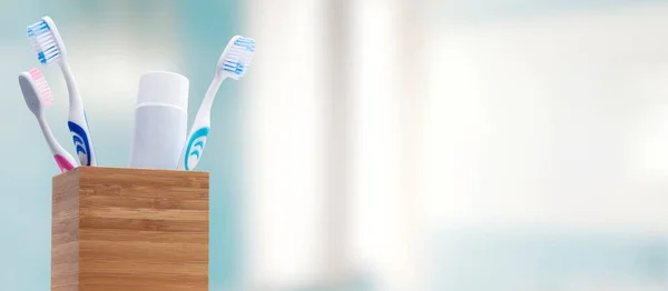 Toothbrush holder with toothbrushes and toothpaste, dental hygiene concept