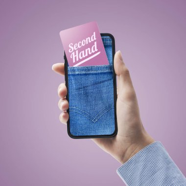 Kadın internet üzerinden akıllı telefonunda ikinci el satış uygulaması, akıllı telefon ekranında kot pantolon cebi ve kartı kullanıyor.