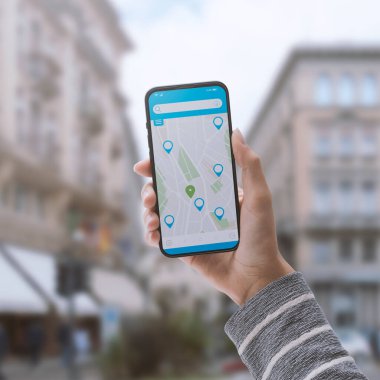 Akıllı telefonunda harita uygulaması kullanarak yön tarifi alan bir kadın.