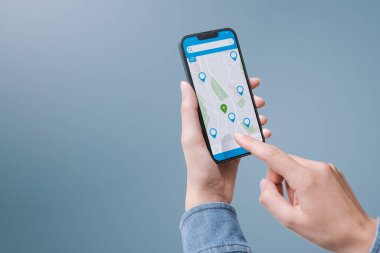 Akıllı telefonunda harita uygulaması kullanarak yön tarifi alan bir kadın.