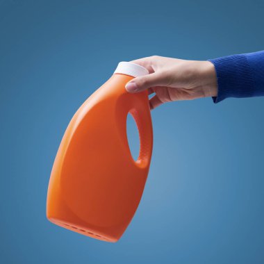 Elinizde plastik deterjan şişesi, ayrı atık toplama ve geri dönüşüm konsepti