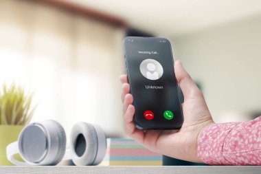 Woman receiving a call on her smartphone from an unknown number, malicious phone calls concept, POV shot
