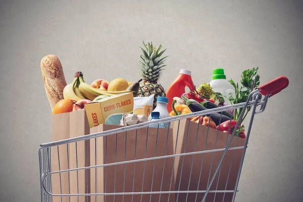 Shopping cart full of fresh groceries, grocery shopping concept