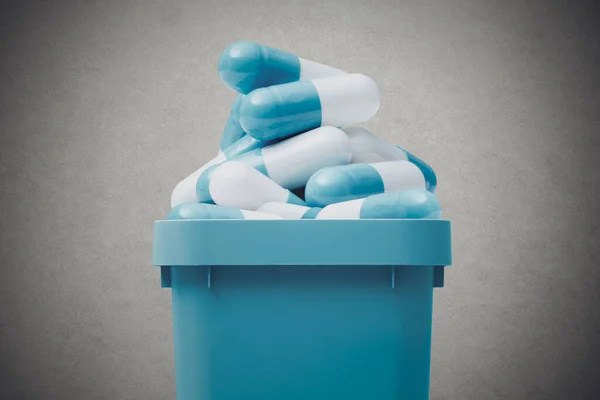 trash can full of expired pills, medical waste disposal concept