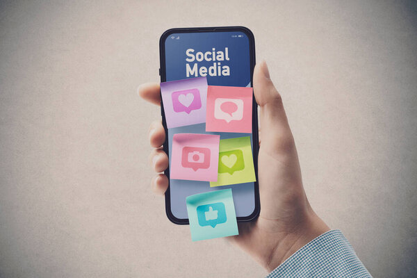 Woman connecting with social media online: sticky notes with icons on smartphone screen, POV shot