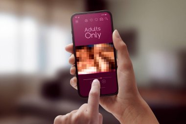 Kadın akıllı telefonuyla porno izliyor. Yetişkinler sadece uygulama kullanıyor.