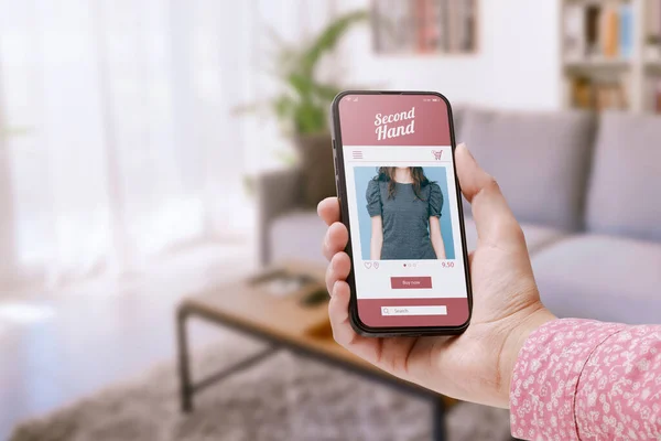 女人们在网上购物时 用的是她的智能手机上的二手销售应用程序 后台是房间内部 Pov镜头 — 图库照片
