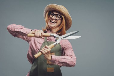 Çit makası, bahçıvanlık ve hobilerle poz veren kendine güvenen bir kadın.