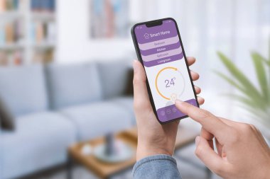 Kadın akıllı telefonunu kullanarak ev sıcaklığını ayarlıyor, akıllı ev otomasyonu konsepti.