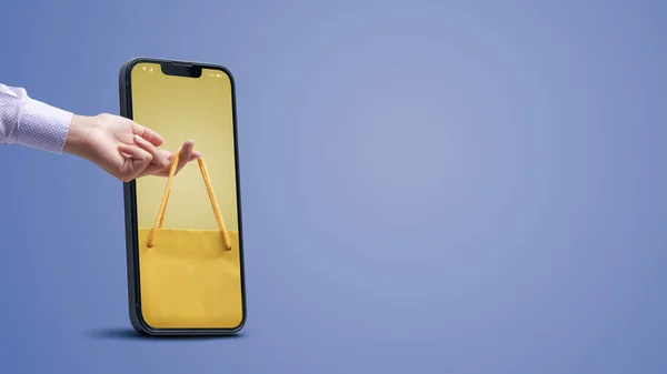女人拿着购物袋在智能手机屏幕上 在线购物应用程序 — 图库照片