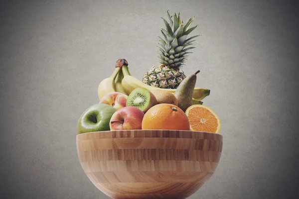 Wooden bowl full of fresh delicious fruit, healthy diet concept