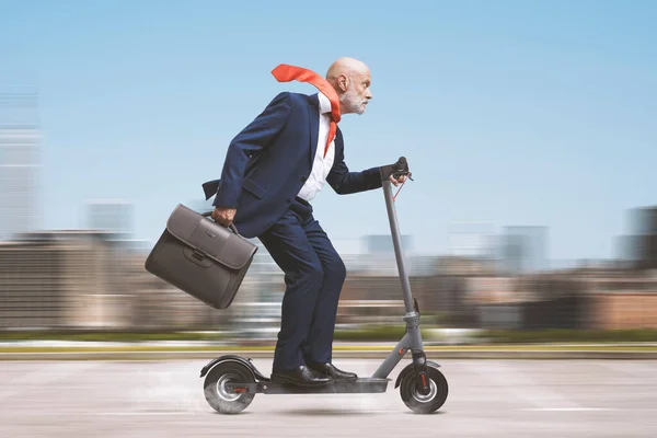市内の電動スクーターに乗る上級企業のビジネスマン — ストック写真