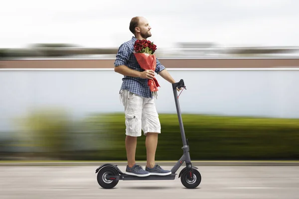 Boldog Ember Randizik Virágot Hoz Barátnőjének Elektromos Robogón Utazik — Stock Fotó