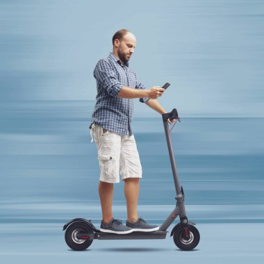 Elektrikli scooter kullanırken akıllı telefon kullanan dikkatsiz bir adam.