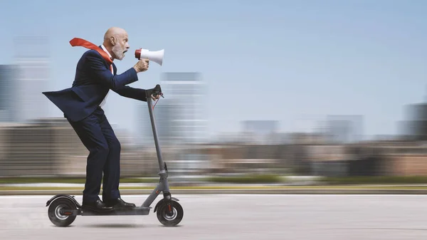 環境に優しい電動スクーターに乗って メガホンを通して叫んでいる企業のビジネスマン — ストック写真
