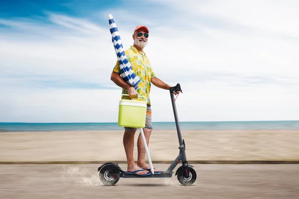 Забавный Пожилой Человек Держащий Пляжный Зонтик Катающийся Электрическом Скутере Идет — стоковое фото