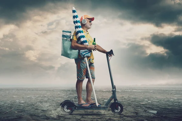 他拿着海滩伞 骑着电动车 微笑着 穿过一片沙漠 — 图库照片