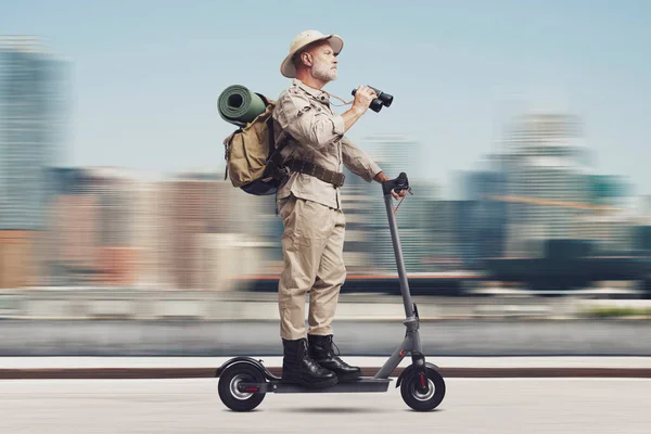 Funny senior urban explorer riding a fast electric scooter in the city street