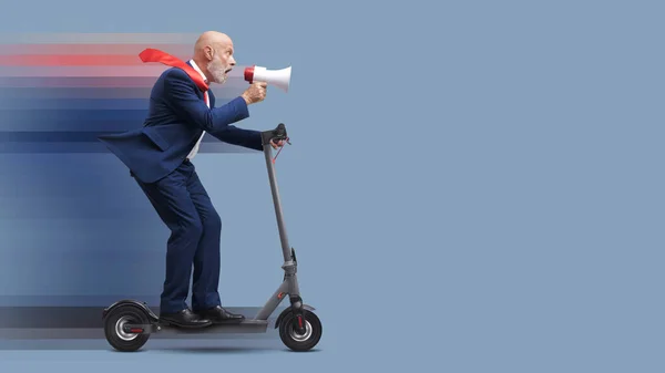 Starszy Biznesmen Korporacyjny Jeździ Szybkim Skuterem Elektrycznym Krzyczy Przez Megafon — Zdjęcie stockowe