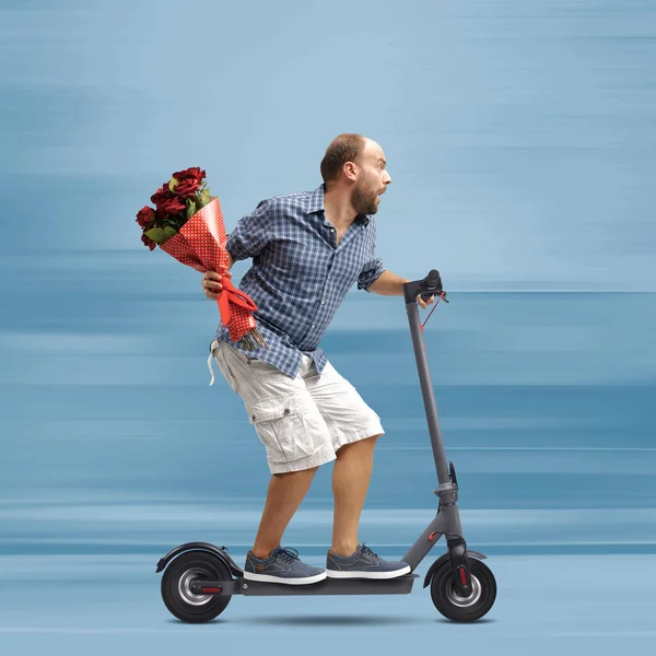 Чоловік Тримає Квіти Їде Швидкому Електричному Скутері Він Запізнюється Побачення — стокове фото