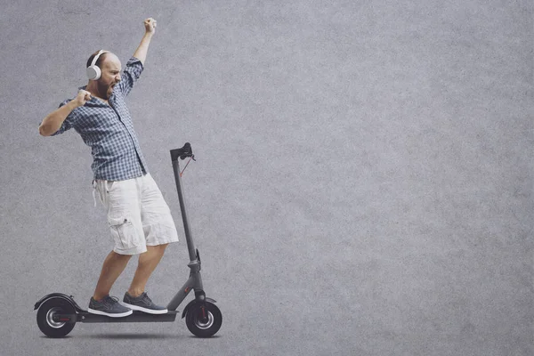 Vrolijke Man Luisteren Naar Muziek Rijden Een Elektrische Scooter Handen — Stockfoto