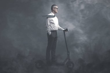 Kıyamet sonrası kirli bir dünyada elektrikli scooter kullanan bir işadamı, etrafı duman ve zehirli gazla çevrili.