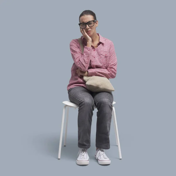 Vrouw Zittend Een Stoel Aanraken Van Haar Wang Heeft Een — Stockfoto