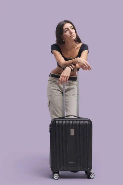 若い旅行者の女性は彼女のトロリーバッグにもたれて待って 彼女は疲れていると失望 — ストック写真