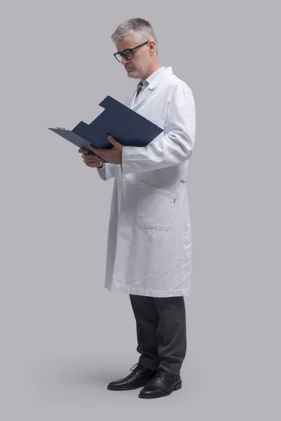 Επαγγελματίας Ιατρός Που Στέκεται Και Ελέγχει Ιατρικά Αρχεία Υγειονομική Περίθαλψη — Φωτογραφία Αρχείου