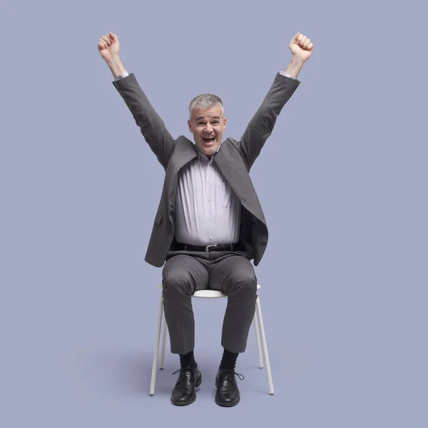 Ευτυχισμένος Επιτυχημένος Άνθρωπος Κάθεται Μια Καρέκλα Και Γιορτάζει Υψωμένα Χέρια — Φωτογραφία Αρχείου