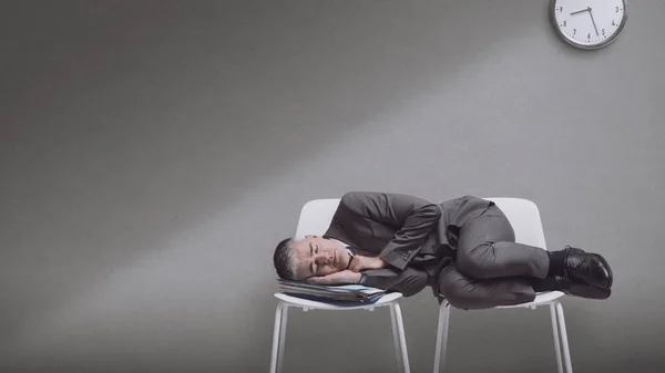 Exhausted lazy corporate businessman lying down on chairs and sleeping, blank copy space