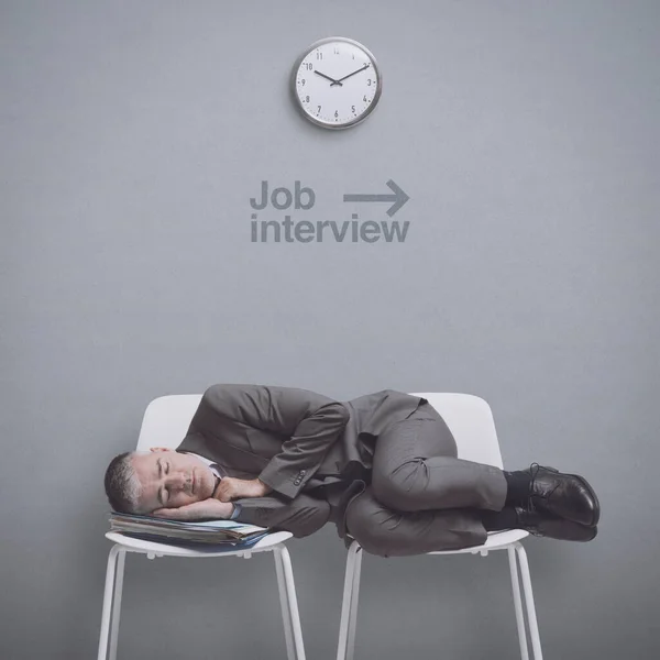 Exhausted job applicant lying on chairs and sleeping in the waiting room, he has been waiting all day long