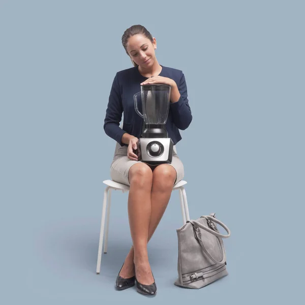 女人拿着搅拌机 坐在椅子上 与灰色背景隔离 — 图库照片