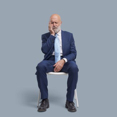 Sandalyeye oturup yanağına dokunan adamın kötü bir diş ağrısı, dişçi ve diş bakımı konsepti var.