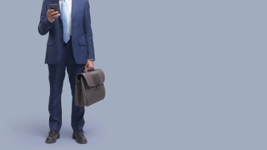 İşadamı internete bağlanıyor ve akıllı telefonunda uygulamalar kullanıyor.