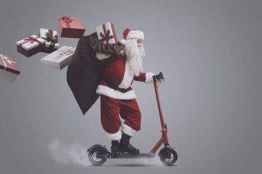 Noel arifesinde hediye getiren hızlı Noel Baba, çevre dostu elektrikli scooter kullanıyor.
