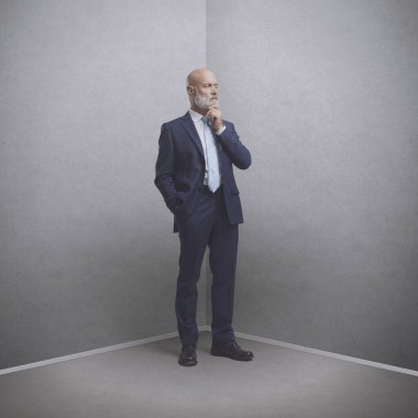 Şirket işadamı köşedeki odada duruyor.