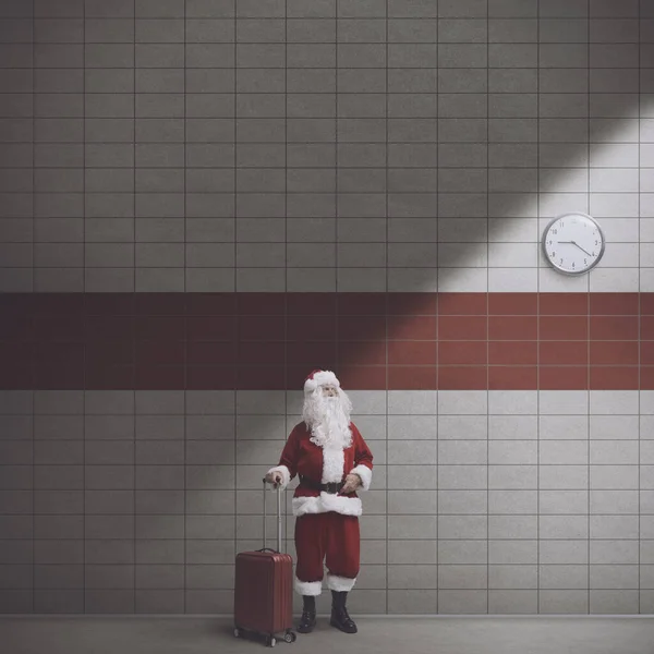サンタクロースとトロリーバッグはクリスマス 観光のコンセプトで駅で待っています — ストック写真