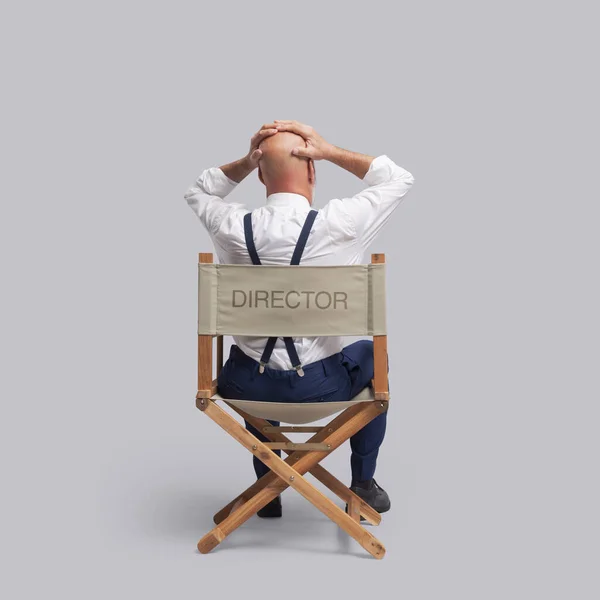 绝望的电影导演手拿着头 坐在导演的椅子上 后视镜 — 图库照片