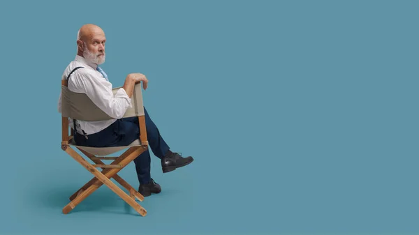 Επαγγελματίας Σκηνοθέτης Αυτοπεποίθηση Κάθεται Στην Καρέκλα Του Σκηνοθέτη Και Κοιτάζει — Φωτογραφία Αρχείου