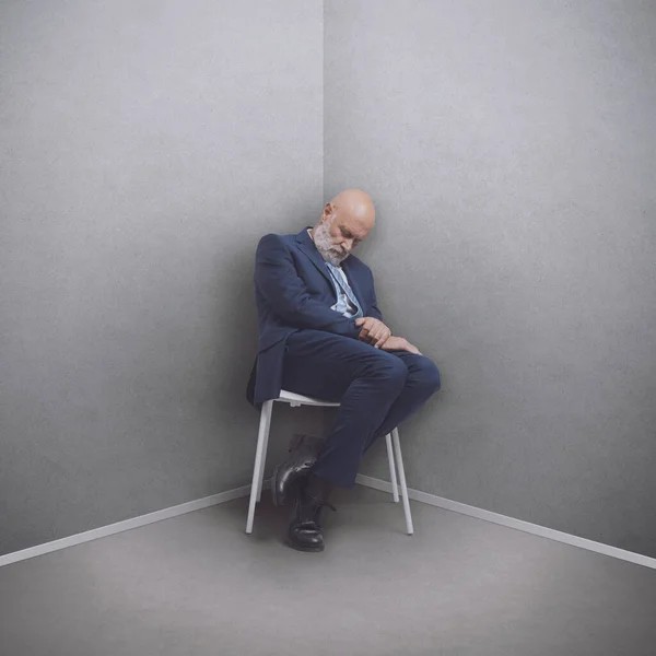 Lazy businessman sitting on a chair and sleeping in a corner in the office