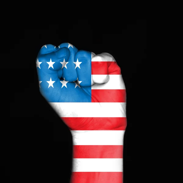Fist painted in colors of american flag over dark background — Stock Photo, Image
