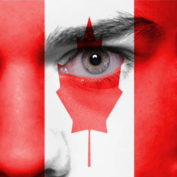 Лицо человека, нарисованное флагом Канады — стоковое фото