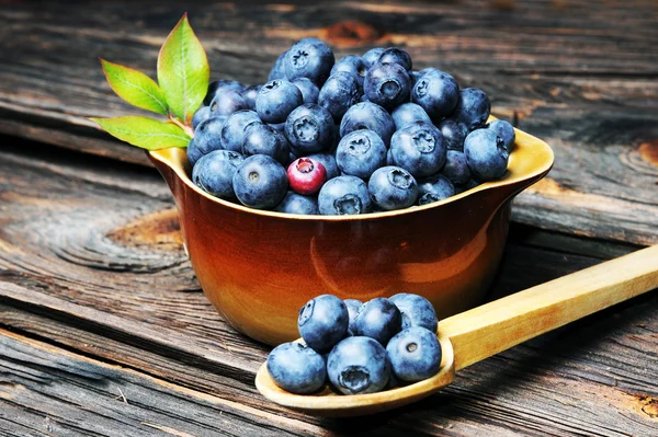 新鲜蓝莓蔓延到木桌上老式木勺从. — 图库照片